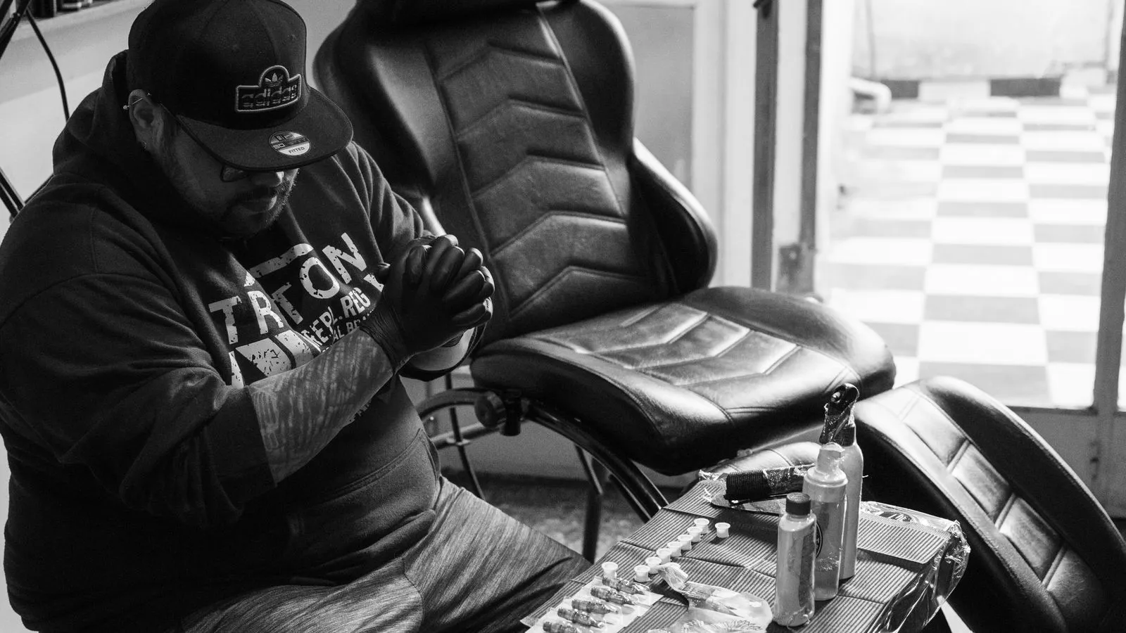 Tattoo artist in a studio setting preparing his tools and workspace.
